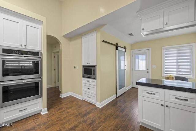 4961 Alcove Ave, Valley Village, CA 91607 - kitchen with stainless steel appliances, arched walkways, dark wood-style flooring, and white cabinetry