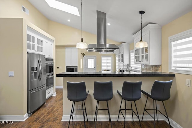4961 Alcove Ave, Valley Village, CA 91607 - kitchen featuring stainless steel appliances, island exhaust hood, a peninsula, a skylight, and white cabinetry