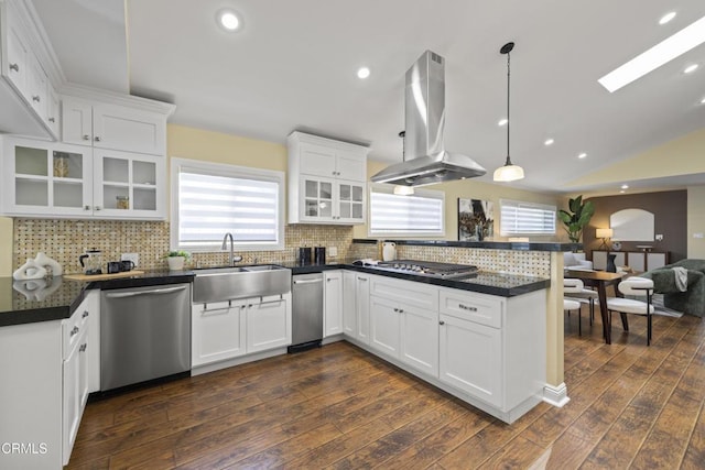 4961 Alcove Ave, Valley Village, CA 91607 - kitchen featuring stainless steel appliances, island range hood, a peninsula, dark countertops, and glass insert cabinets