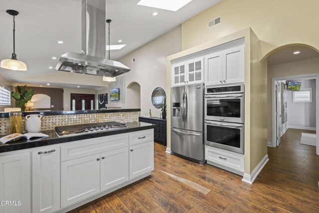 4961 Alcove Ave, Valley Village, CA 91607 - kitchen featuring appliances with stainless steel finishes, island exhaust hood, arched walkways, dark countertops, and recessed lighting