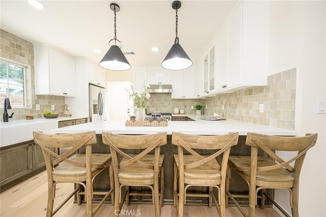 240 Rosemont Blvd, San Gabriel, CA 91775 - kitchen with under cabinet range hood, stainless steel fridge, backsplash, light wood-style floors, and light countertops