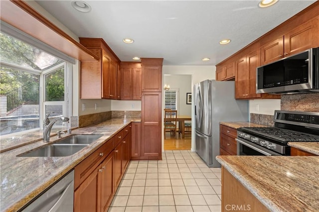 28610 Cloverleaf Pl, Castaic, CA 91384 - kitchen featuring stainless steel appliances, light tile patterned floors, recessed lighting, light stone countertops, and brown cabinets