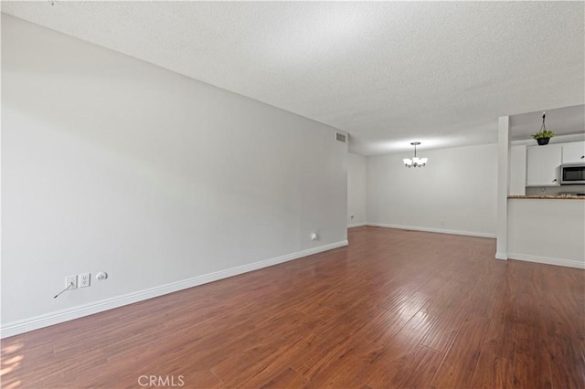 25735 Hogan Dr Unit E11, Valencia, CA 91355 - unfurnished living room with a chandelier, wood finished floors, and a textured ceiling