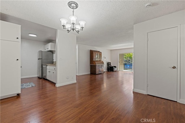 25735 Hogan Dr Unit E11, Valencia, CA 91355 - unfurnished living room with a textured ceiling, dark wood-style flooring, and a chandelier