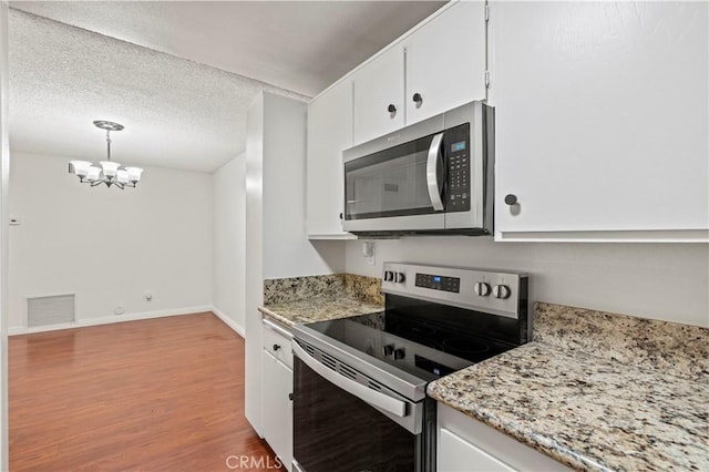 25735 Hogan Dr Unit E11, Valencia, CA 91355 - kitchen featuring stainless steel appliances, wood finished floors, white cabinets, a chandelier, and a textured ceiling