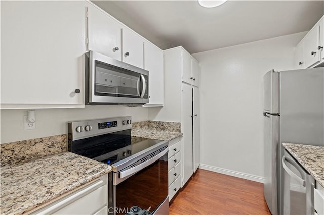 25735 Hogan Dr Unit E11, Valencia, CA 91355 - kitchen with stainless steel appliances, light wood finished floors, white cabinets, and light stone countertops