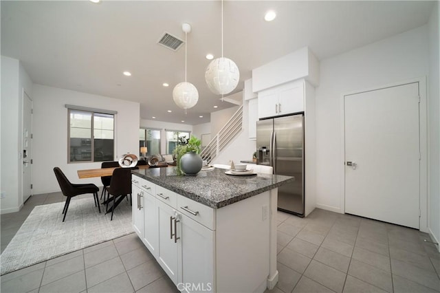185 Magnet, Irvine, CA 92618 - kitchen featuring stainless steel fridge with ice dispenser, light tile patterned floors, a center island, dark stone counters, and white cabinets