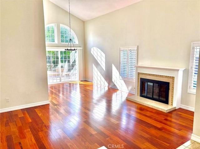 72 Coral Unit 38, Irvine, CA 92614 - unfurnished living room with high vaulted ceiling, wood finished floors, and a tiled fireplace