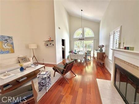 72 Coral Unit 38, Irvine, CA 92614 - living area with light wood finished floors, high vaulted ceiling, and a tiled fireplace