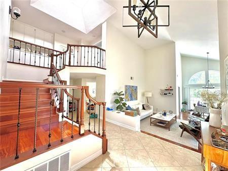 72 Coral Unit 38, Irvine, CA 92614 - stairs featuring high vaulted ceiling, a chandelier, and tile patterned flooring