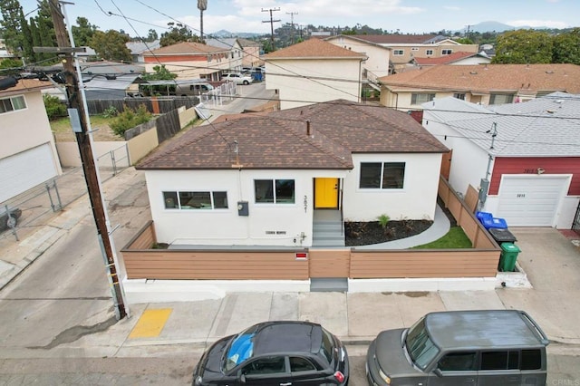 3821 Shiloh Rd, San Diego, CA 92105 - view of front facade with stucco siding, a residential view, a garage, and roof with shingles