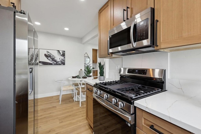 3821 Shiloh Rd, San Diego, CA 92105 - kitchen featuring appliances with stainless steel finishes, light wood-style flooring, recessed lighting, light stone countertops, and brown cabinetry