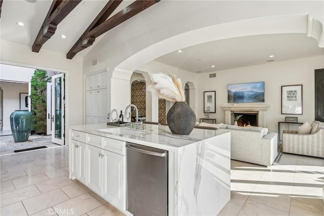 3 Coral Cay, Newport Coast, CA 92657 - kitchen featuring dishwasher, arched walkways, open floor plan, light stone countertops, and white cabinetry
