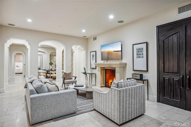3 Coral Cay, Newport Coast, CA 92657 - living area featuring recessed lighting, arched walkways, light marble finish floors, and a lit fireplace