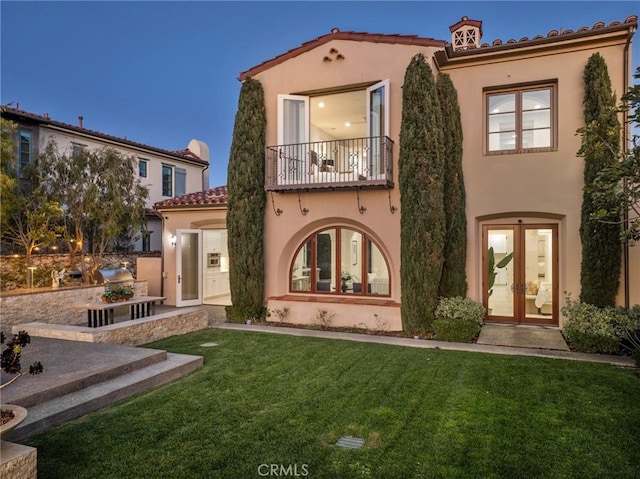 3 Coral Cay, Newport Coast, CA 92657 - rear view of property with french doors, a balcony, stucco siding, a lawn, and a tiled roof