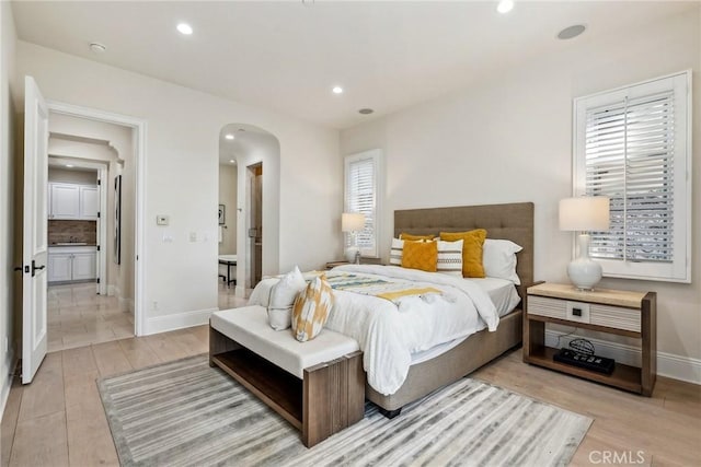 3 Coral Cay, Newport Coast, CA 92657 - bedroom featuring arched walkways, light wood finished floors, recessed lighting, and ensuite bath