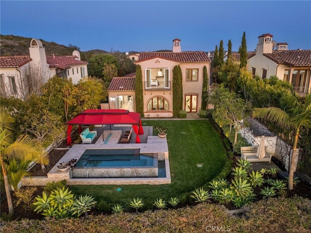 3 Coral Cay, Newport Coast, CA 92657 - rear view of property featuring a chimney, outdoor lounge area, a tile roof, an in-ground hot tub, and an outdoor pool