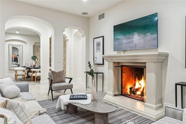 3 Coral Cay, Newport Coast, CA 92657 - living area featuring a lit fireplace, marble finish flooring, and arched walkways