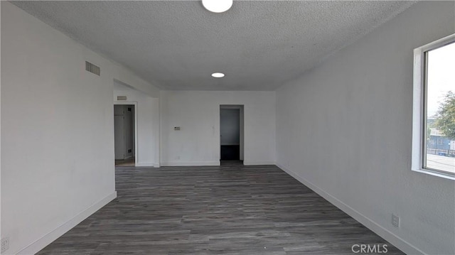 9614 Graham Ave, Los Angeles, CA 90002 - empty room with a textured ceiling and dark wood finished floors
