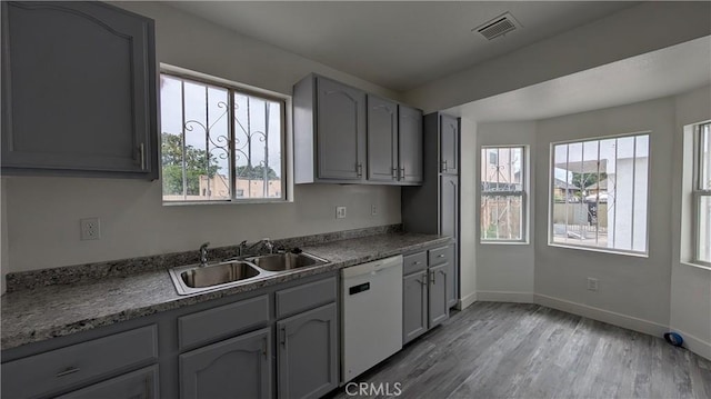 9614 Graham Ave, Los Angeles, CA 90002 - kitchen with white dishwasher, plenty of natural light, light wood finished floors, and gray cabinetry