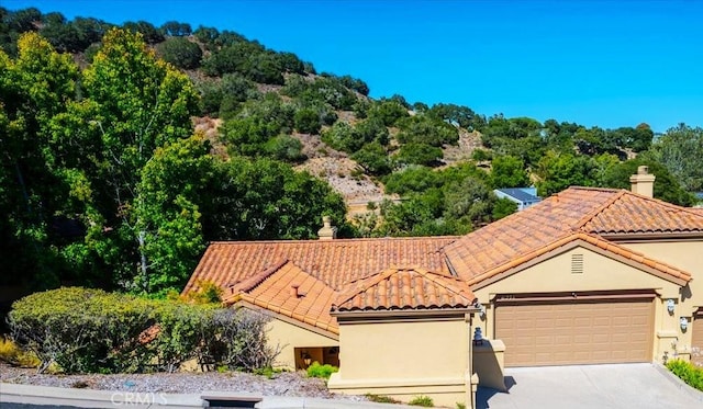 6271 Twinberry Cir Unit 6, Avila Beach, CA 93424 - view of front of home featuring a tiled roof, stucco siding, concrete driveway, a garage, and a chimney