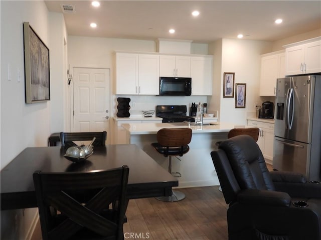 975 W Clover Ave, Rialto, CA 92376 - kitchen featuring black microwave, stainless steel refrigerator with ice dispenser, dark wood finished floors, light countertops, and stove