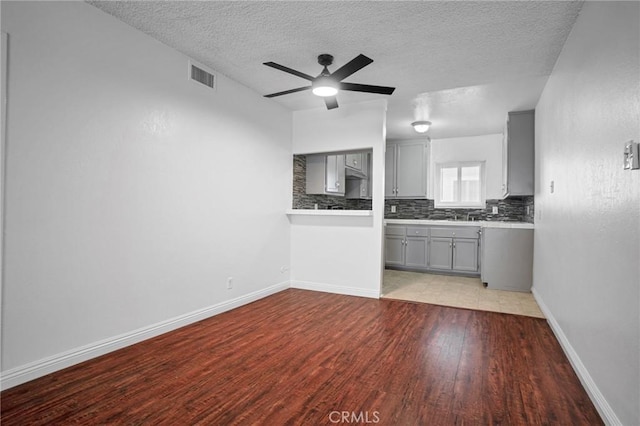 218 E Tamarack Ave Unit 5, Inglewood, CA 90301 - kitchen featuring gray cabinetry, tasteful backsplash, wood finished floors, a textured ceiling, and light countertops