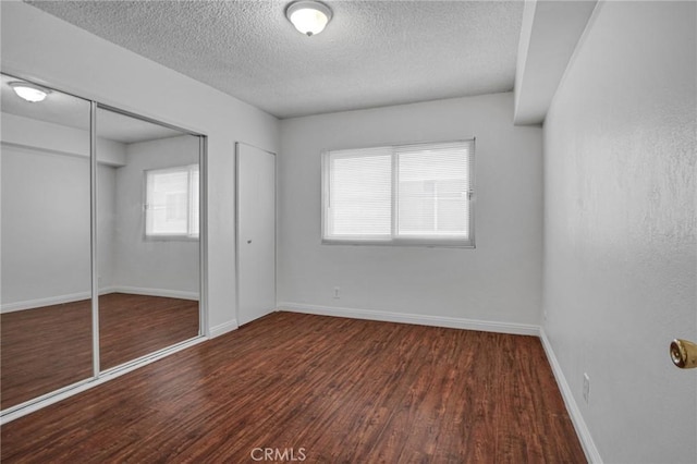 218 E Tamarack Ave Unit 5, Inglewood, CA 90301 - unfurnished bedroom featuring a textured ceiling, wood finished floors, multiple windows, and two closets