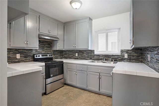 218 E Tamarack Ave Unit 5, Inglewood, CA 90301 - kitchen with electric range, tile countertops, under cabinet range hood, and gray cabinetry