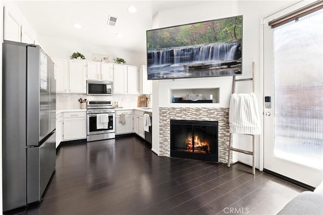 1474 De La Vina St, Chula Vista, CA 91913 - kitchen featuring appliances with stainless steel finishes, white cabinets, light countertops, a tile fireplace, and backsplash