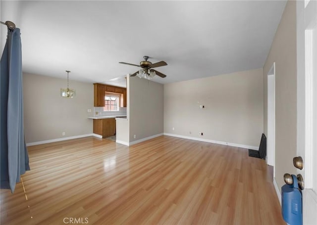15511 Gramercy Pl, Gardena, CA 90249 - unfurnished living room featuring ceiling fan, light wood-style floors, and a chandelier