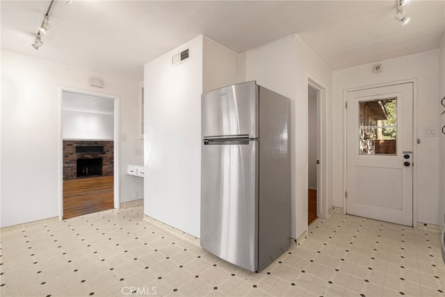 1245 Palm Ave, Chico, CA 95926 - kitchen with freestanding refrigerator, track lighting, light floors, and a stone fireplace