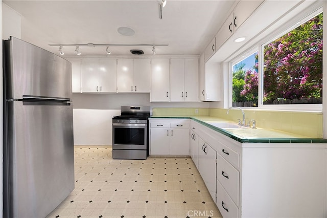 1245 Palm Ave, Chico, CA 95926 - kitchen featuring appliances with stainless steel finishes, rail lighting, white cabinetry, and tile counters