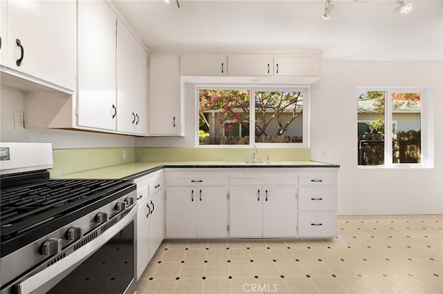 1245 Palm Ave, Chico, CA 95926 - kitchen with stainless steel range with gas stovetop, light floors, white cabinets, and light countertops