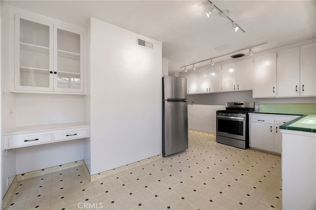 1245 Palm Ave, Chico, CA 95926 - kitchen featuring appliances with stainless steel finishes, track lighting, white cabinetry, light floors, and glass insert cabinets