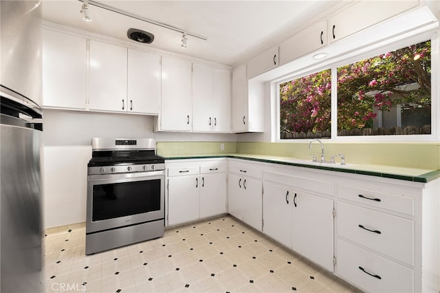 1245 Palm Ave, Chico, CA 95926 - kitchen with stainless steel stove, fridge, white cabinets, and rail lighting