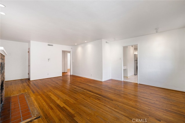 1245 Palm Ave, Chico, CA 95926 - unfurnished living room with a brick fireplace, wood finished floors, and recessed lighting