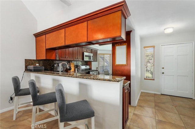 810 Baker St Unit 210, Costa Mesa, CA 92626 - kitchen featuring appliances with stainless steel finishes, plenty of natural light, dark stone counters, and tasteful backsplash