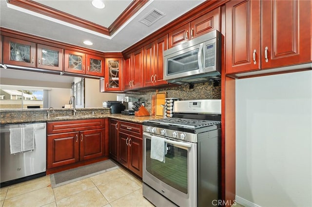 810 Baker St Unit 210, Costa Mesa, CA 92626 - kitchen with stainless steel appliances, a tray ceiling, reddish brown cabinets, recessed lighting, and ornamental molding
