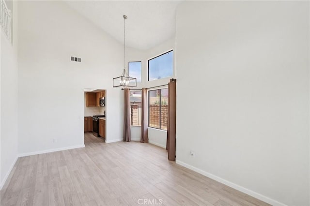 1122 W Galway St, Rialto, CA 92377 - unfurnished dining area with a chandelier, light wood-style flooring, and high vaulted ceiling