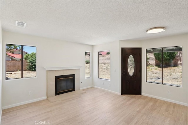 1122 W Galway St, Rialto, CA 92377 - foyer entrance featuring a textured ceiling, wood finished floors, and a fireplace