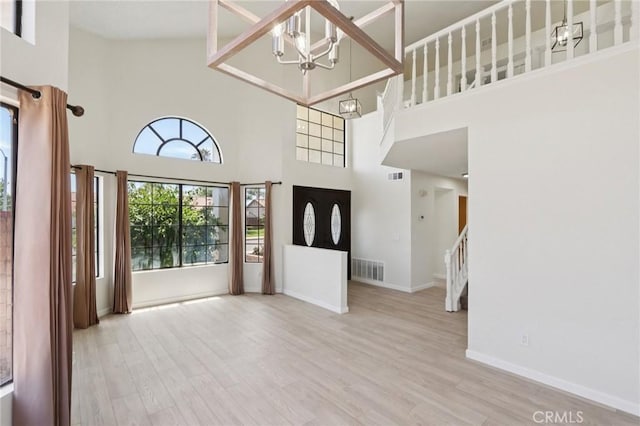 1122 W Galway St, Rialto, CA 92377 - entryway with a high ceiling, stairs, wood finished floors, and a chandelier