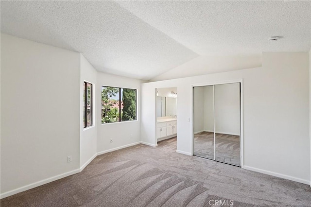 1122 W Galway St, Rialto, CA 92377 - unfurnished bedroom featuring a textured ceiling, carpet, lofted ceiling, a closet, and connected bathroom