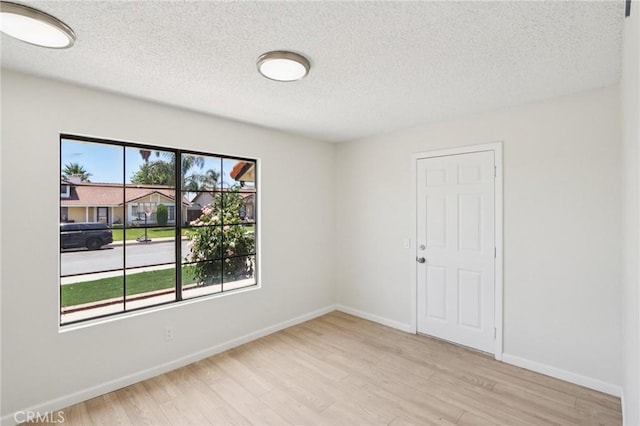 1122 W Galway St, Rialto, CA 92377 - empty room with light wood-style floors and a textured ceiling