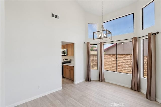 1122 W Galway St, Rialto, CA 92377 - unfurnished dining area featuring a chandelier, high vaulted ceiling, and light wood finished floors