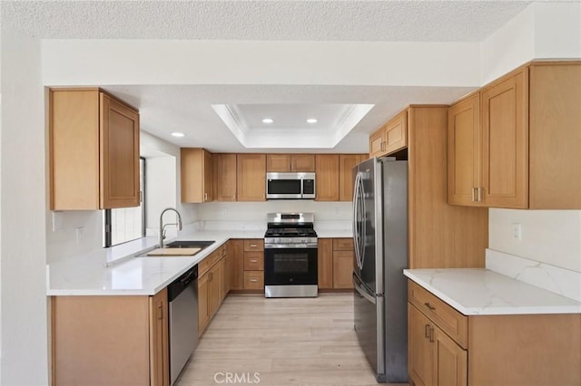 1122 W Galway St, Rialto, CA 92377 - kitchen with appliances with stainless steel finishes, light wood-style flooring, recessed lighting, a tray ceiling, and a textured ceiling