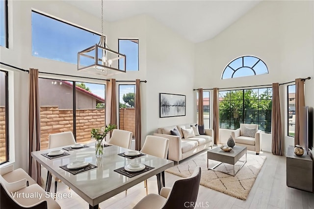 1122 W Galway St, Rialto, CA 92377 - dining space featuring a chandelier, high vaulted ceiling, and wood finished floors