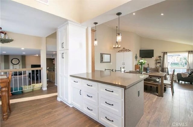 25491 2nd St, Lake Forest, CA 92630 - kitchen featuring vaulted ceiling, wood finished floors, white cabinetry, pendant lighting, and open floor plan