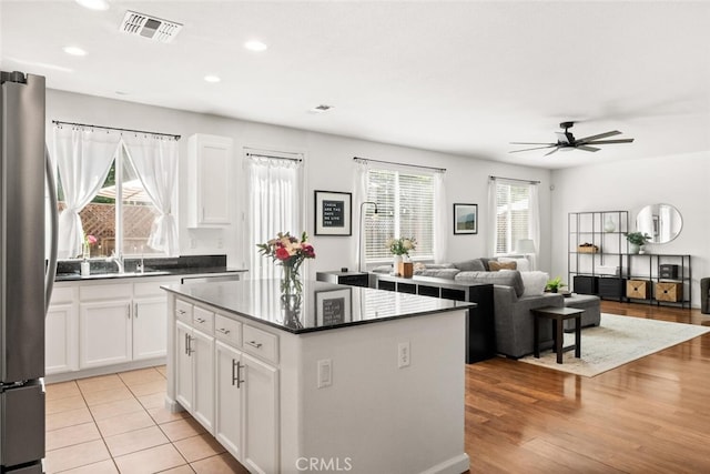 3192 Sawyers Bar Ln, Chico, CA 95973 - kitchen with a center island, a ceiling fan, freestanding refrigerator, recessed lighting, and white cabinets