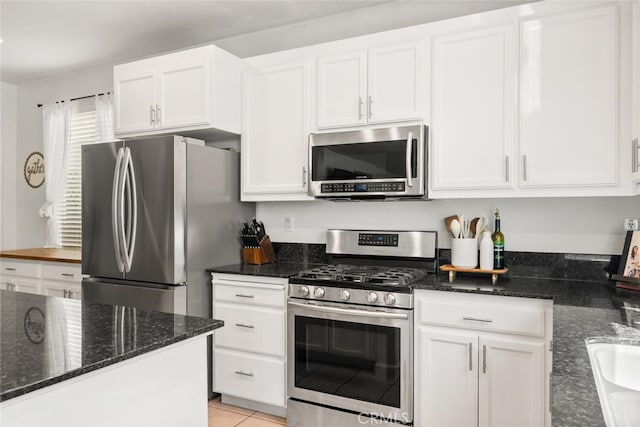 3192 Sawyers Bar Ln, Chico, CA 95973 - kitchen featuring appliances with stainless steel finishes, white cabinets, dark stone counters, and light tile patterned floors